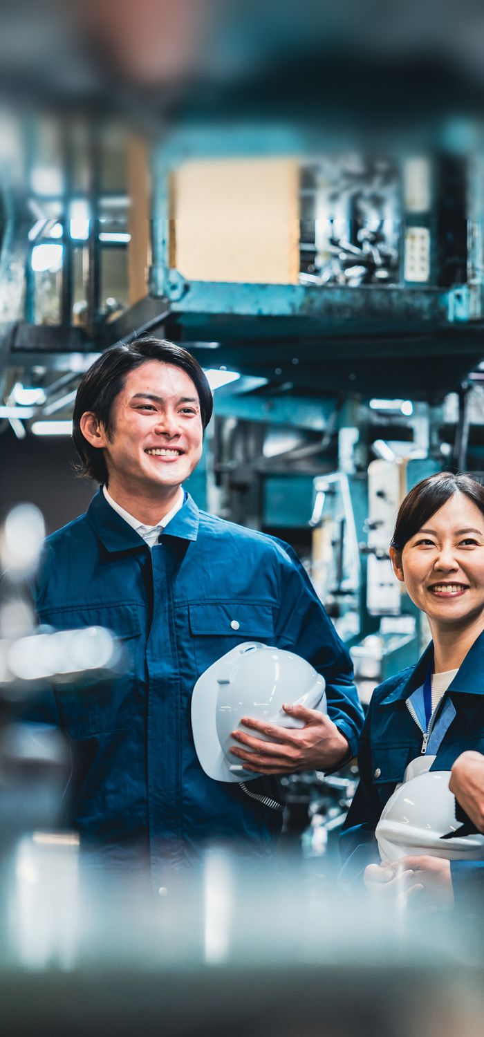 ヘルメットを手に語らう製造現場の従業員